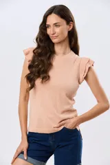 Remera tejida de algodón en color beige, de cuello redondo, sin mangas y con detalles de volados estructurados en los hombros.