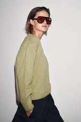 Jersey de punto confeccionado en lana 100%, con escote en pico y manga larga de corte holgado.