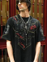 Remera de algodón con efecto acid wash y corte boxy fit. Presenta un estampado frontal que simula una armadura medieval con detalles en rojo y remaches, extendiéndose hacia las mangas.