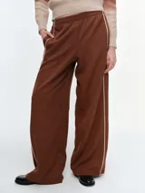 Pantalón de corte recto y holgado, color marrón, con cintura elástica y detalle de ribetes laterales en color blanco.