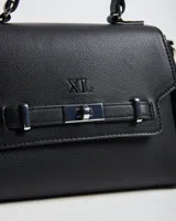 Cartera chica XL Extra Large de símil cuero negro con textura granulada, asa superior y correa bandolera regulable y desmontable. Cuenta con solapa frontal con logo grabado, detalle de tira con cierre giratorio metálico plateado y herrajes a tono.