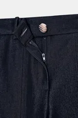 Pantalón de tiro alto con pernera recta, confeccionado en denim oscuro. Presenta nervios marcados en el delantero, bolsillos frontales tipo parche y cierre frontal con cremallera y botón.