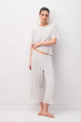 Pijama de modal jersey color gris claro melange, compuesto por una remera de manga corta con detalles de encaje en las terminaciones y un pantalón largo a juego con encaje en el ruedo.