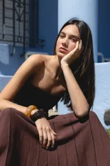 Falda larga de tejido de punto color marrón, con diseño plisado y líneas verticales en contraste.