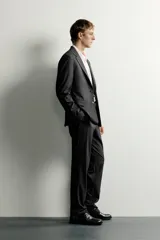 Blazer slim fit de corte estructurado color gris oscuro, confeccionado en tejido con viscosa, con solapas de muesca, bolsillos con solapa en la cadera y cierre frontal de un botón.