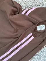 Remerón oversize de algodón color chocolate con mangas cortas y dos tiras rosas en los hombros.