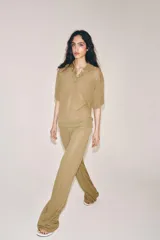 Pantalón de pierna recta color tostado, con tiro medio y cintura elástica. Confeccionado en hilatura con mezcla de viscosa.