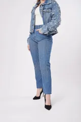 Pantalón de jean azul con detalles de strass plateados.