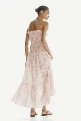 Vestido midi strapless en mezcla de viscosa, con estampado paisley en tonos rosados, azules y marrones sobre base beige. Presenta cuerpo fruncido elástico con volados en el escote y falda con corte escalonado.