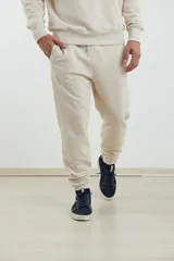 Pantalón jogging de tejido circular con cintura elástica y cordón ajustable. Presenta puños elastizados en el ruedo y bolsillos laterales.