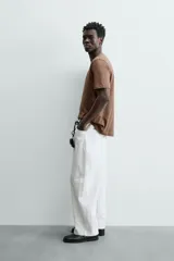 Remera color arena de corte recto, cuello redondo y mangas cortas.