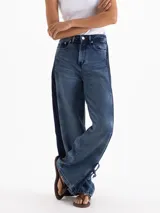 Jeans Roses Bow de tiro medio y calce holgado, con pierna amplia y lavado azul intermedio. Cuenta con recortes laterales en contraste y detalles de lazos regulables en los tobillos.