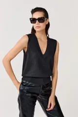 Chaleco tejido negro con lurex, escote en V y terminaciones de rib.
