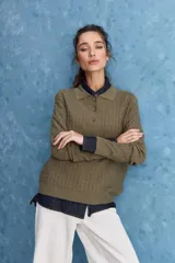 Sweater de punto color verde militar, con cuello polo y cierre frontal de botones, de manga larga con puños elastizados y diseño texturizado con relieve geométrico.