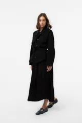 Chaqueta negra de calce relajado y estilo utilitario, con bolsillos delanteros XL, cierre frontal de botones, cuello camisero y cinturón regulable en la cintura.