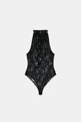 Body negro confeccionado en encaje semitransparente, con diseño sin mangas y cuello halter alto con detalle de tejido plisado. Cierre inferior con broches a presión.