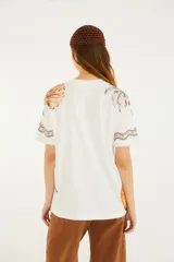 Remera blanca de manga corta y cuello redondo de la marca Farm Rio, con estampado gráfico veraniego que incluye un cono de helado, palmeras y caracoles.