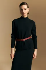 Polera de cuello alto confeccionada en tejido de punto negro, con diseño de textura acanalada en cuello, puños y ruedo, y trama vertical en mangas y espalda.