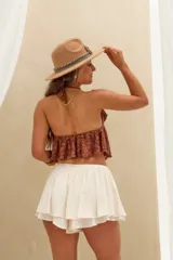 Top halter marrón con diseño de múltiples volados en cascada y textura floral en relieve.
