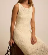 Vestido midi color crema, tejido en punto texturizado, sin mangas y con cuello redondo.