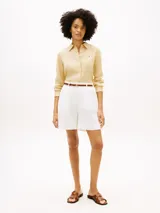 Camisa de lino puro color beige, de corte amplio y mangas largas, con cuello inglés, cierre frontal de botones y logo bordado en el pecho. Marca Tommy Hilfiger.