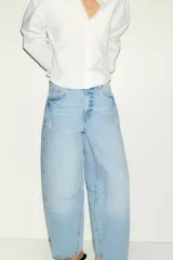 Jean tobillero de cinco bolsillos en denim de algodón rígido, con diseño curvo y volumen en las piernas de tiro alto.