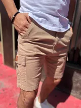 Bermuda cargo de gabardina color beige, con bolsillos laterales con solapa y cierre frontal.