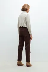 Pantalón de vestir marrón chocolate con cinturón de cuero a tono.