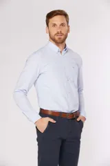 Camisa de manga larga con diseño de rayas finas en color celeste, cuello con botones y bolsillo ojal en el pecho.