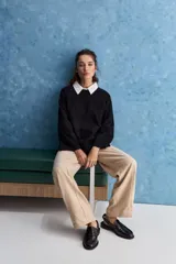 Sweater blanco de punto con diseño holgado, cuello redondo, mangas largas acampanadas y detalles de textura horizontal en el tejido.