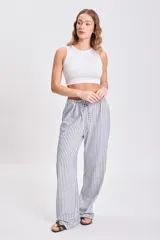 Pantalón de pijama de corte recto, con cintura elástica y cordón ajustable, con estampado de rayas verticales azules y blancas.