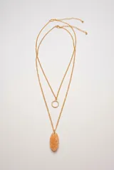 Collar doble dorado con dijes de aro metálico y piedra ovalada texturada.