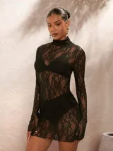 Vestido corto de encaje negro con cuello tortuga y mangas largas.