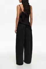 Pantalón de mezclilla negro de corte wide leg, con diseño holgado y tiro bajo.