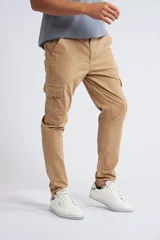 Pantalón cargo de corte slim, color beige, con cierre y botón frontal, bolsillos laterales tipo cargo y terminación recta sin puños.