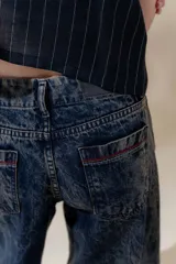 Pantalón de jean con tiro medio y piernas anchas, color azul con efecto lavado.