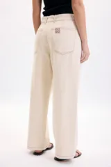 Pantalón casual beige de corte recto, con bolsillos laterales y pespuntes en contraste.