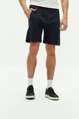 Short de felpa azul marino con textura, bolsillos laterales y uno trasero, cintura regulable con cordón y logo bordado.