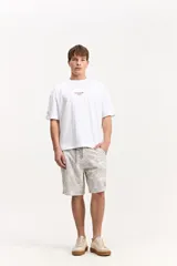 Short de baño estilo surf color gris claro con estampado botánico, longitud media, cintura con cordón ajustable y bolsillo trasero con solapa.
