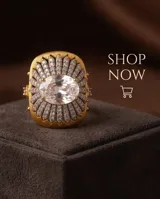 Anillo grande de bronce con baño de oro, diseño texturizado en forma de flor con incrustaciones de circón pavé y una piedra central ovalada transparente.