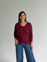 Sweater de punto en color bordó, con escote en V, mangas largas y diseño de corte recto con dobladillo ligeramente más largo en la parte posterior.