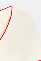 Top de punto color marrón con escote redondo amplio, manga corta y detalles de ribetes en color amarillo contrastante en el cuello, los puños y el ruedo.