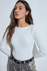 Body de manga larga en color blanco, con cuello redondo y ajuste al cuerpo. Presenta un diseño minimalista y versátil, ideal para usar como prenda base.