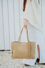 Cartera tipo tote de cuero con textura grabada tipo cocodrilo, color marrón. Cuenta con doble asa de hombro, cierre metálico frontal con detalle de borla y herrajes dorados.