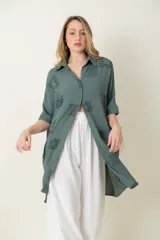 Camisa larga de manga corta, calce holgado, color verde con estampado de motivos en forma de medallones o cuadrados con diseño ornamental.