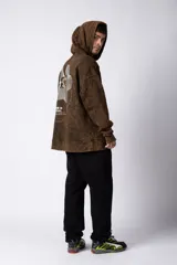 Buzo canguro con capucha, de calce oversize y efecto de lavado ácido en tono marrón. Presenta un bolsillo frontal tipo canguro y un pequeño estampado minimalista en el pecho.