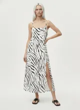 Vestido midi con estampado de cebra en blanco y negro, de tirantes finos y escote recto. Tiene una abertura lateral en la falda.