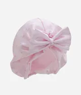 Gorro turbante de satén color rosa con estampado sutil de moños y un gran moño decorativo frontal.