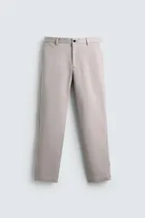 Pantalón chino de corte regular fit, confeccionado en tejido de algodón con elasticidad. Presenta bolsillos frontales, bolsillos traseros de vivo y cierre frontal con cremallera y botón.
