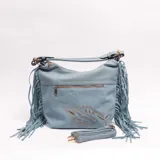 Cartera bandolera celeste de cuero sintético con flecos en los laterales, detalles bordados y dorados en el frente, y cierre superior. Cuenta con un bolsillo frontal con cierre y correa ajustable y desmontable.